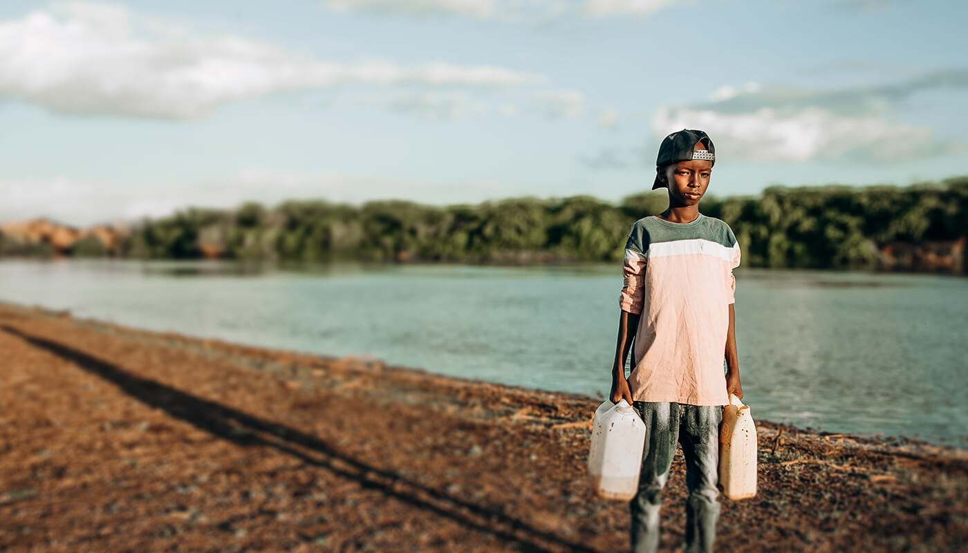 Boy carrying jerry cans